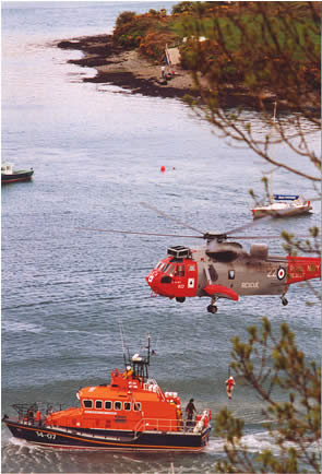 Courtmacsherry "Trent" type All-Weather lifeboat exercising with an Royal Navy Sea-King helicopter (from RNAS Culdrose) in Kinsale harbour, 2002.